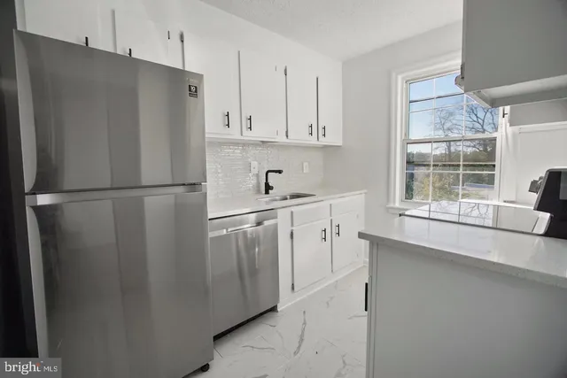 a kitchen with stainless steel appliances a refrigerator sink and cabinets