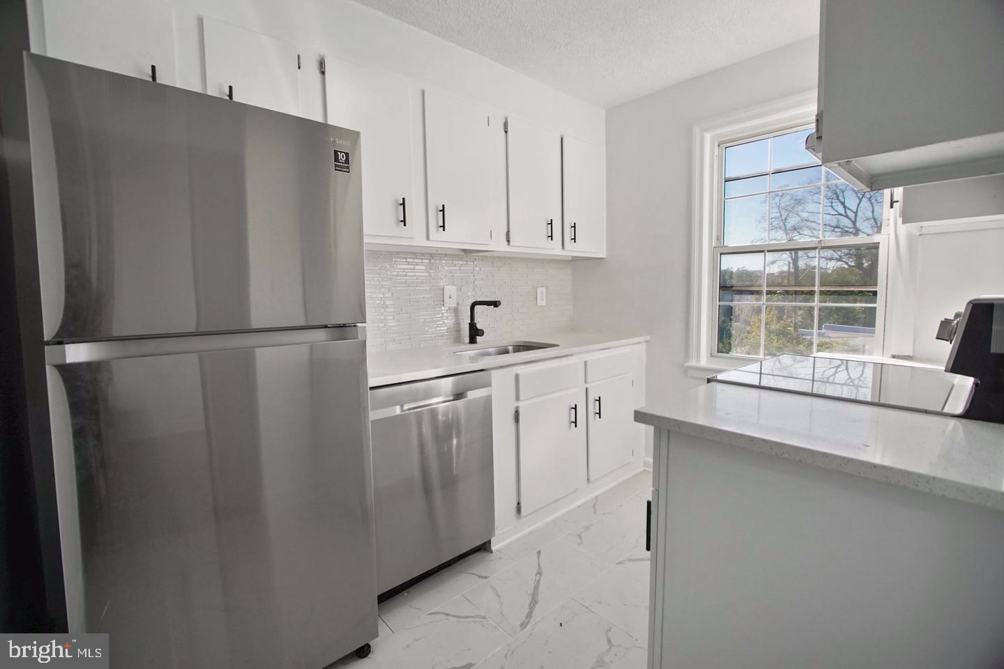 2111 Suitland Terrace Southeast, Unit 302 Washington, DC 20020 - Photo 10 of 11 a kitchen with stainless steel appliances a refrigerator sink and cabinets