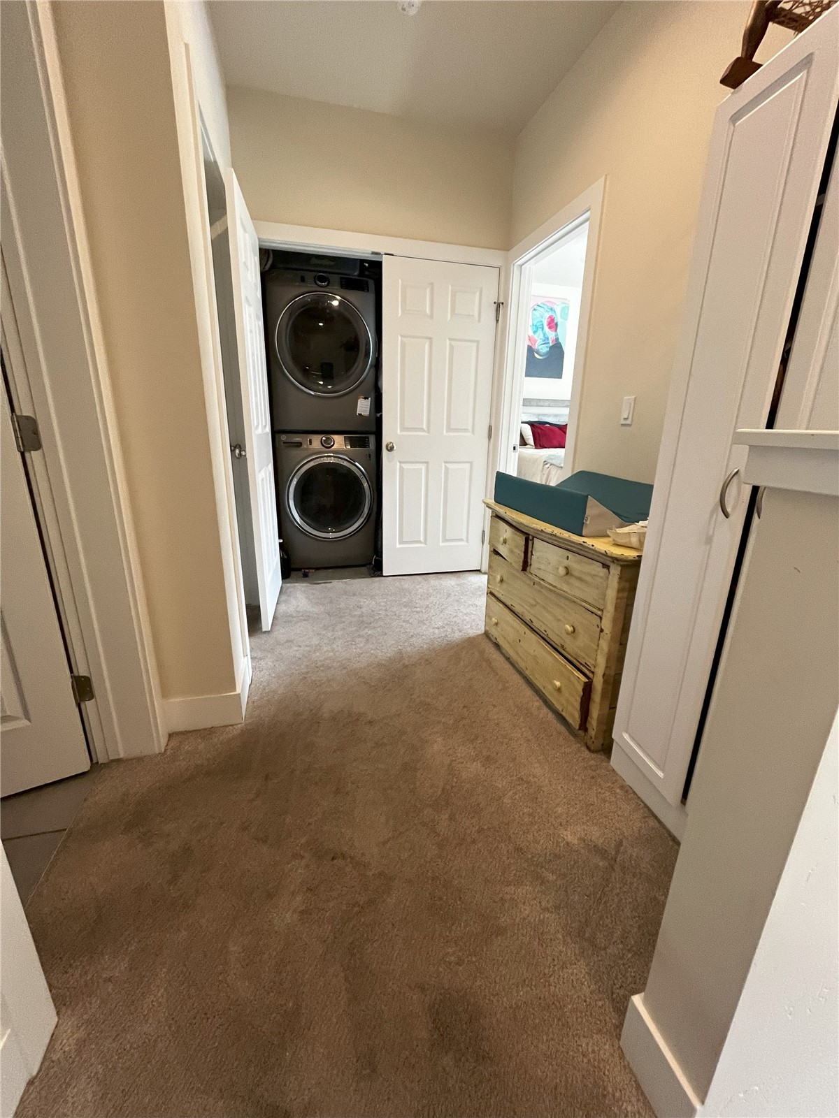 315 Smith Ranch Road, Unit 9B Silverthorne, CO 80498 - Photo 8 of 10 Hall featuring stacked washing maching and dryer and light carpet