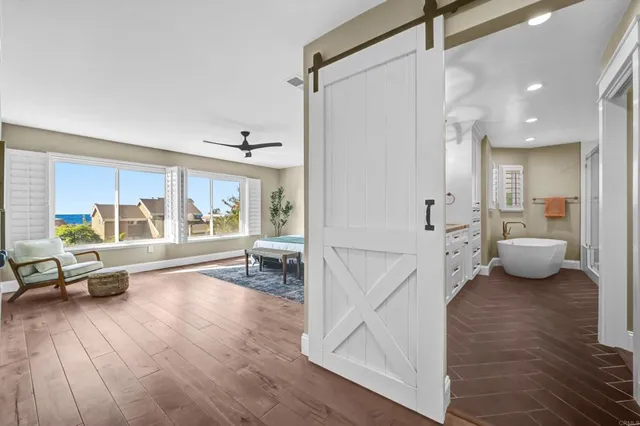 a bedroom with a bed wooden floor and windows
