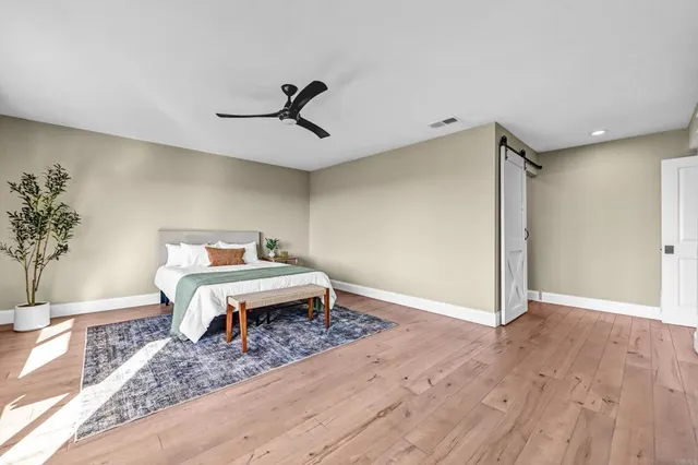 a bedroom with a bed and wooden floor