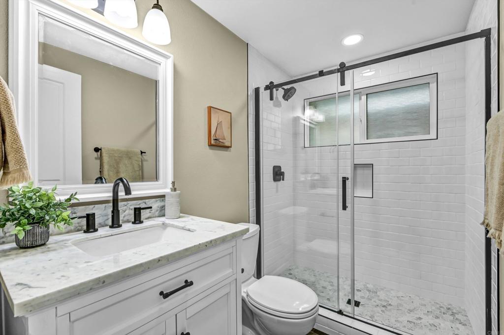 1760 Gascony Road Encinitas, CA 92024 - Photo 25 of 49 a bathroom with a shower sink vanity mirror and toilet