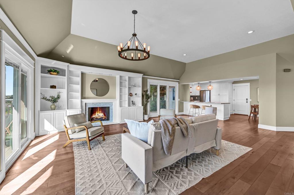 1760 Gascony Road Encinitas, CA 92024 - Photo 4 of 49 a living room with furniture a fireplace and a dining table with wooden floor