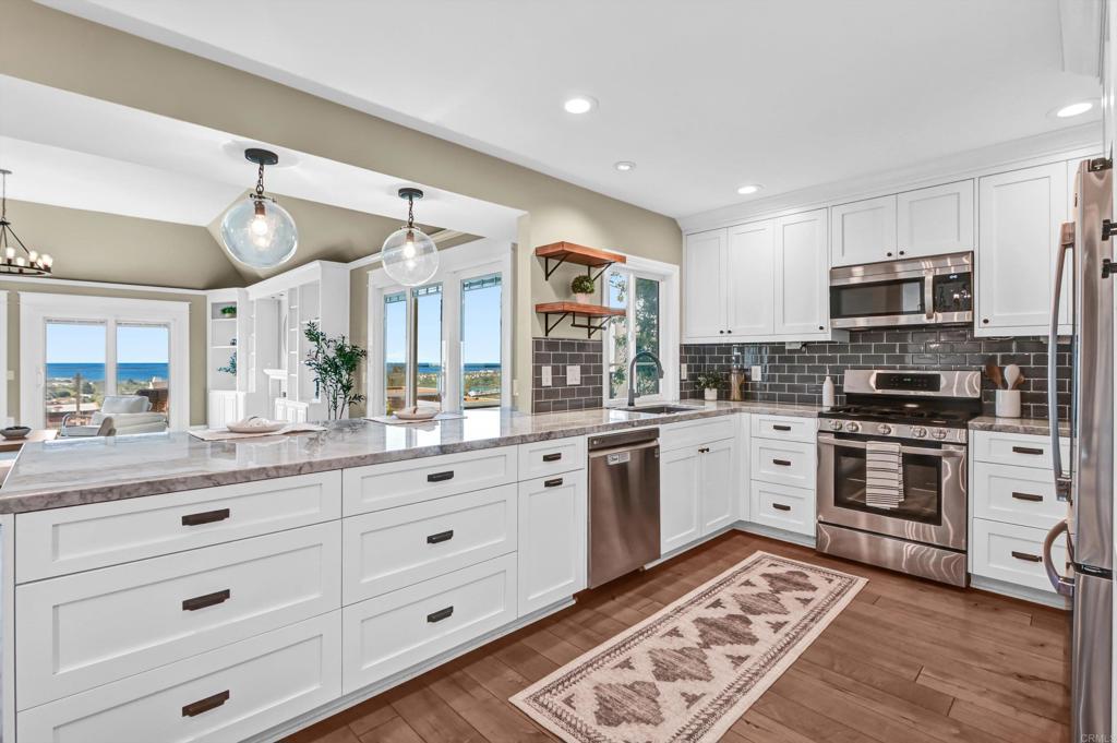 1760 Gascony Road Encinitas, CA 92024 - Photo 6 of 49 a kitchen with granite countertop white cabinets and stainless steel appliances