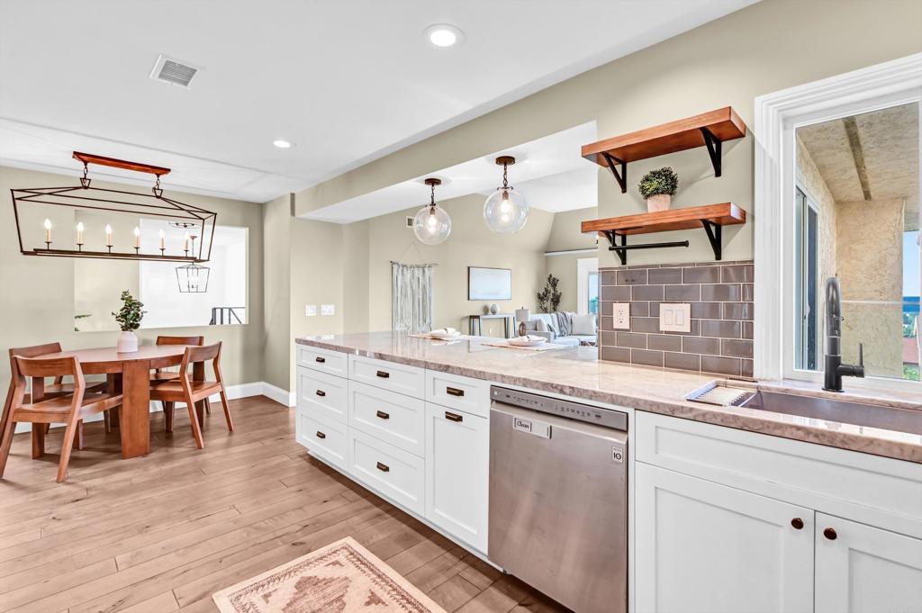 1760 Gascony Road Encinitas, CA 92024 - Photo 7 of 49 a large kitchen with cabinets a sink and a dining table view