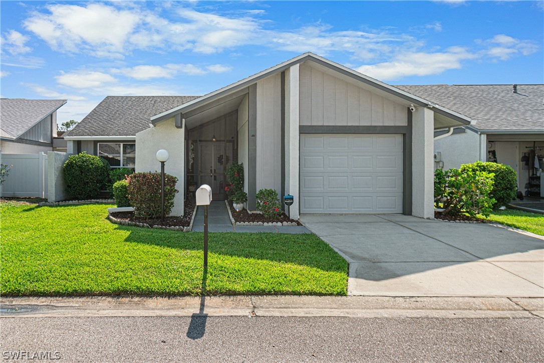 9701 Baycrest Terrace Lehigh Acres, FL 33936 - Photo 1 of 50 a front view of a house with a yard and garage