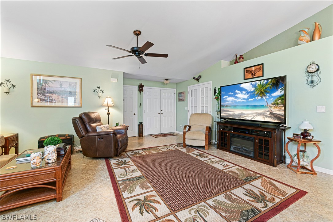 9701 Baycrest Terrace Lehigh Acres, FL 33936 - Photo 12 of 50 a living room with furniture a flat screen tv and paintings on the wall