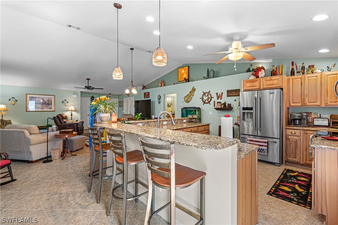 9701 Baycrest Terrace Lehigh Acres, FL 33936 - Photo 20 of 50 a kitchen with stainless steel appliances kitchen island granite countertop a refrigerator a stove top oven a sink dishwasher and white cabinets with wooden floor