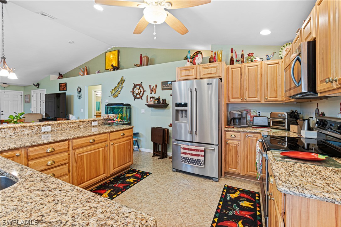 9701 Baycrest Terrace Lehigh Acres, FL 33936 - Photo 21 of 50 a kitchen with stainless steel appliances granite countertop a refrigerator and a stove top oven