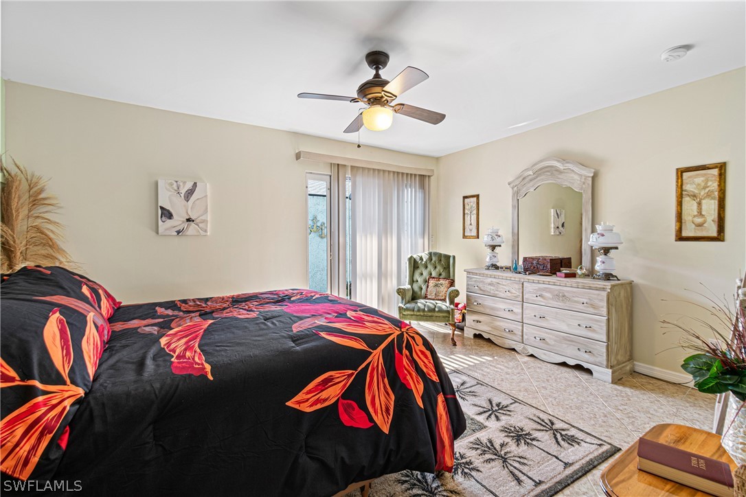 9701 Baycrest Terrace Lehigh Acres, FL 33936 - Photo 42 of 50 a bedroom with a bed and a chandelier