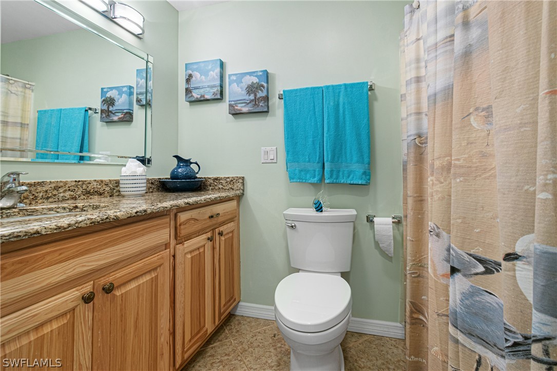 9701 Baycrest Terrace Lehigh Acres, FL 33936 - Photo 47 of 50 a bathroom with a granite countertop toilet sink and mirror