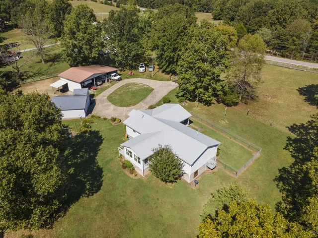 an aerial view of a house with a yard and lake view