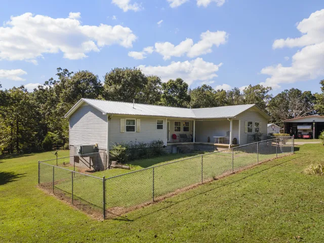 a view of a house with backyard and sitting area