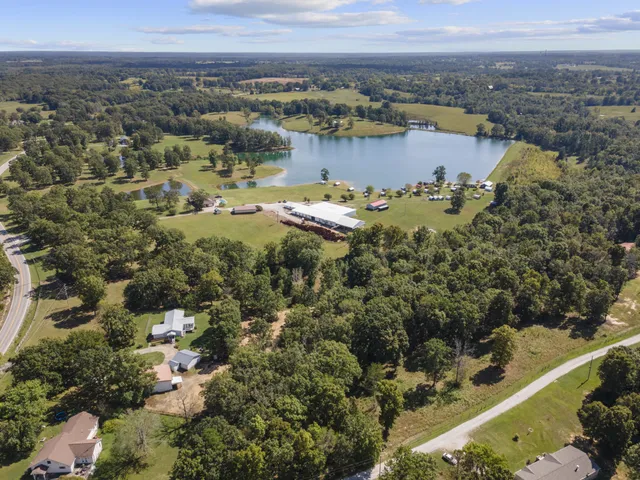 an aerial view of a houses with a yard and lake view