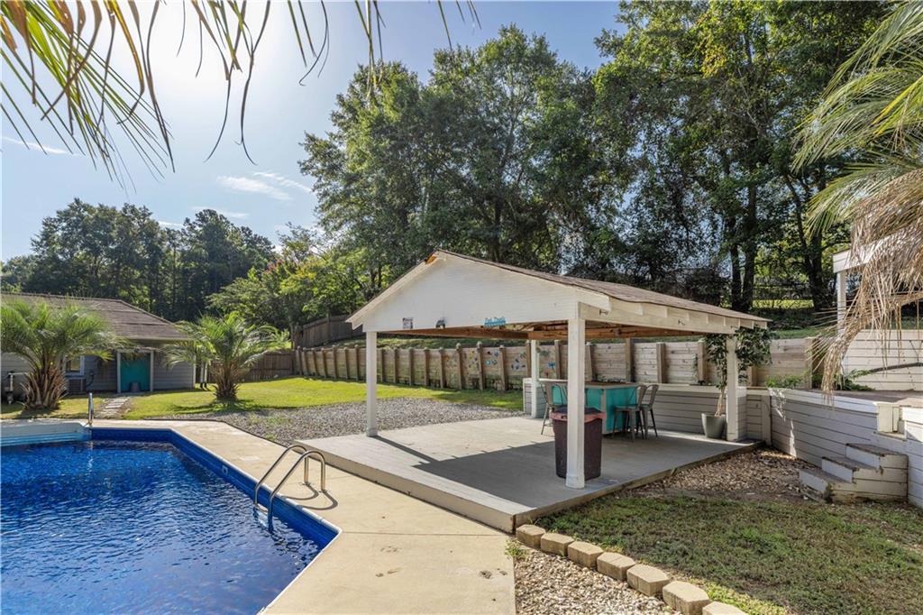 4 Ford Road Phenix City, AL 36869 - Photo 40 of 52 In-ground swimming pool with ladder, covered patio area, and built-in outdoor bar