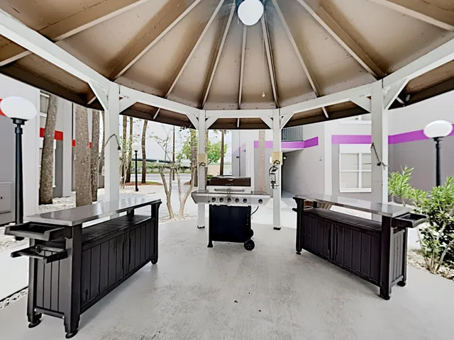 a view of a white house with a large tree