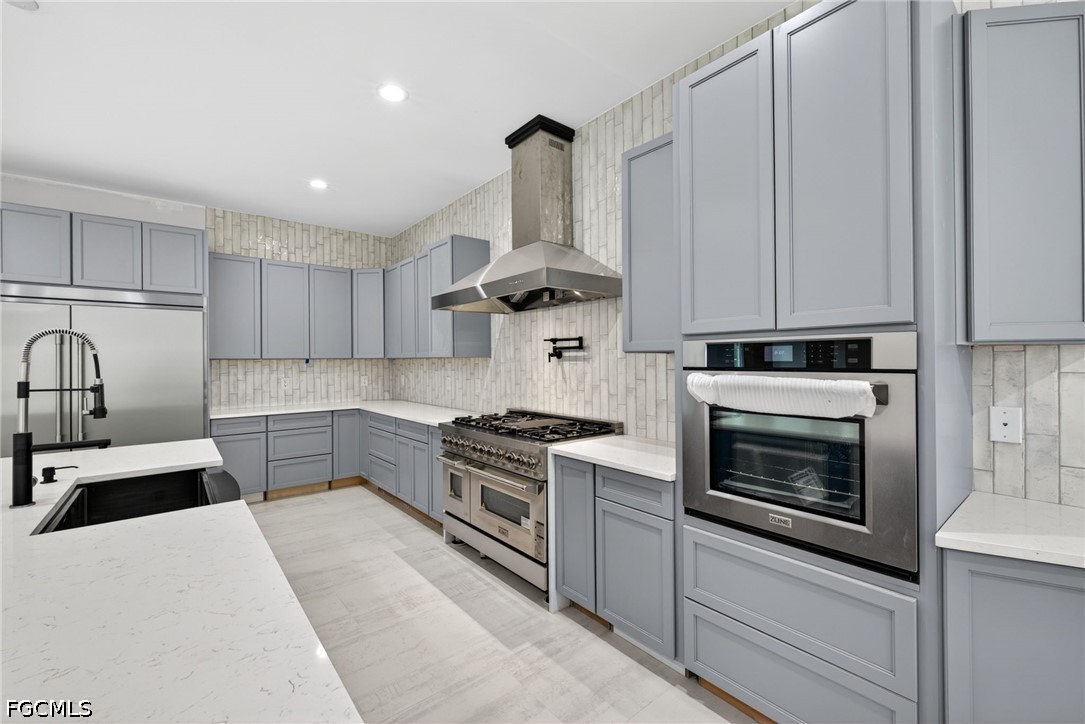 2665 Oil Well Road Naples, FL 34120 - Photo 4 of 40 a kitchen with stainless steel appliances a stove sink and cabinets