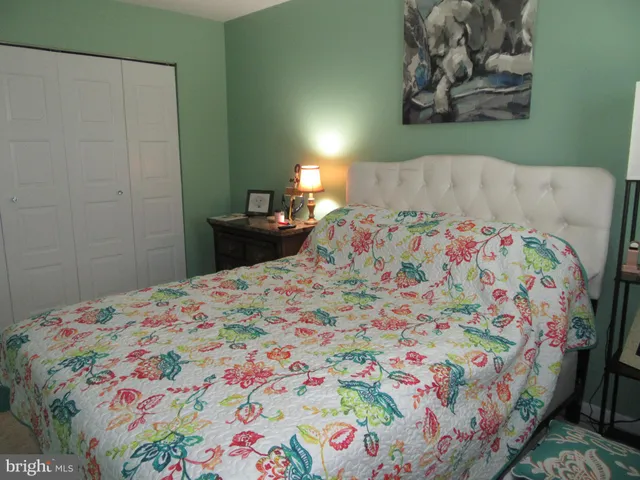a bedroom with a bed and painting on the wall