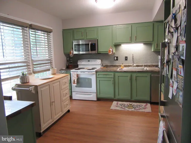 a kitchen with a sink cabinets and wooden floor