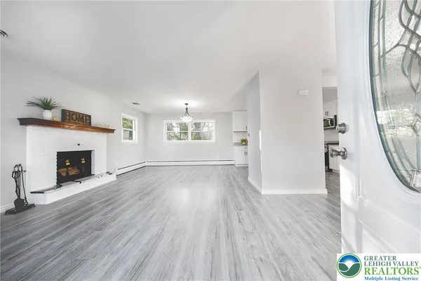 a view of a livingroom with wooden floor and a fireplace