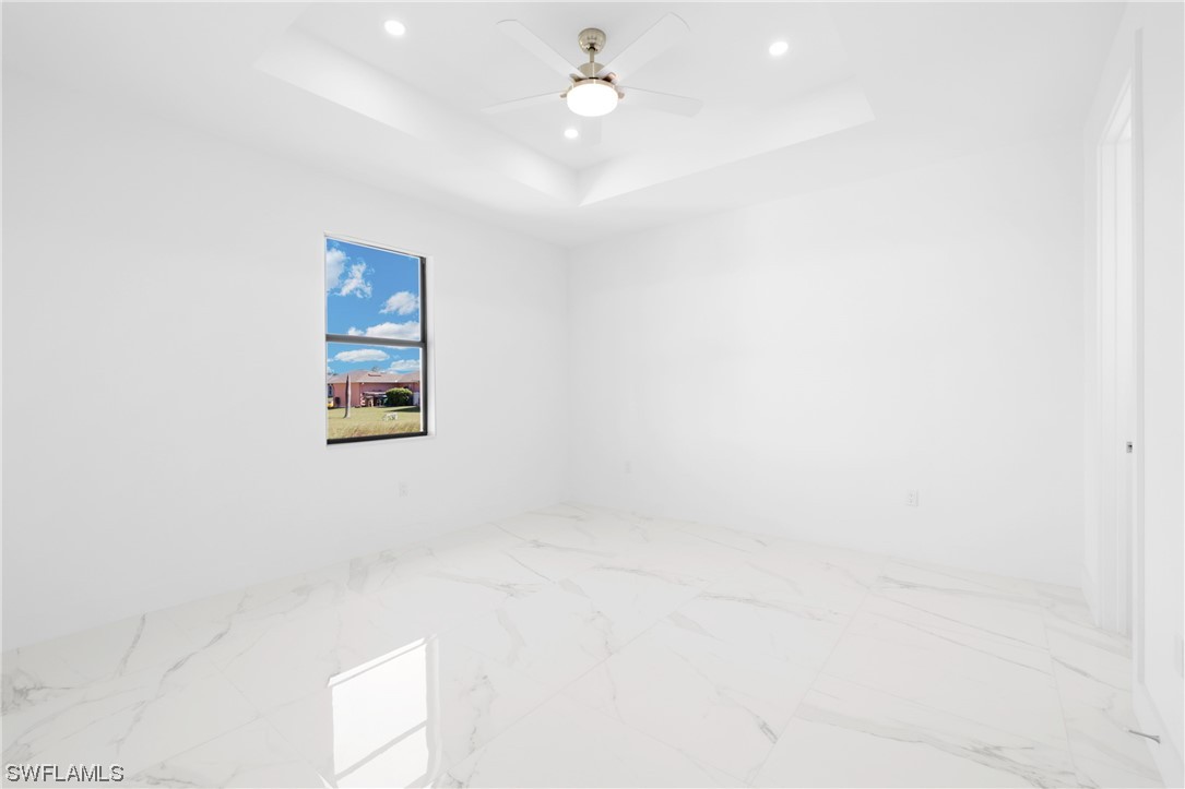 2917 Nelson Road North Cape Coral, FL 33993 - Photo 11 of 25 an empty room with windows and ceiling fan