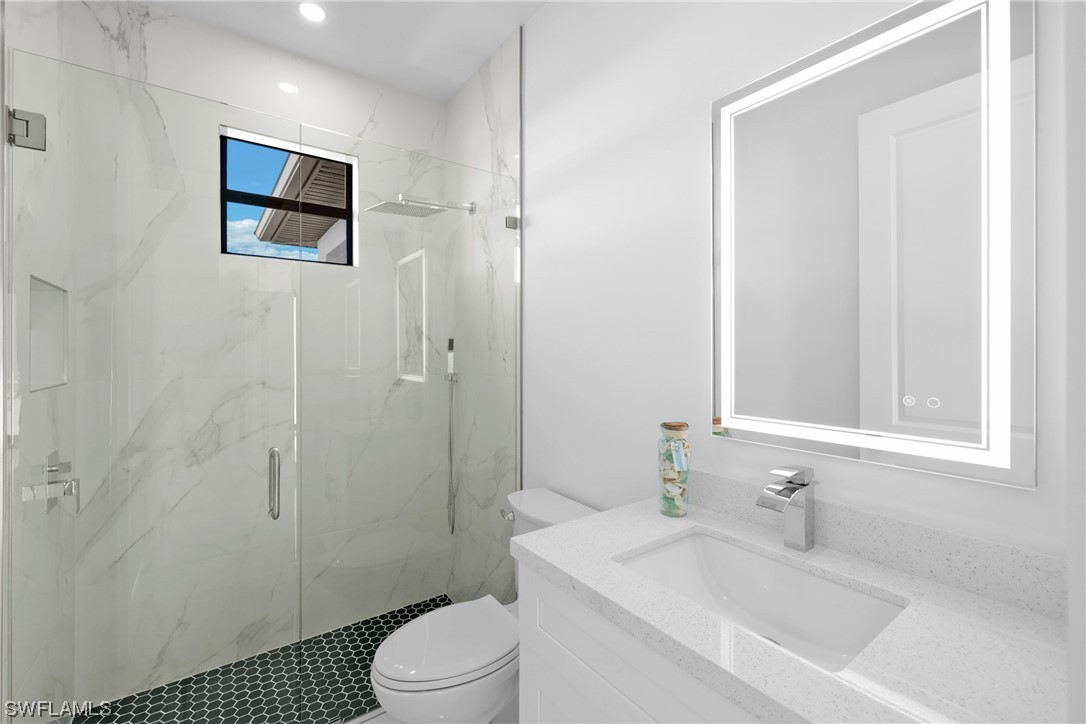 2917 Nelson Road North Cape Coral, FL 33993 - Photo 13 of 25 a bathroom with a sink a toilet and shower