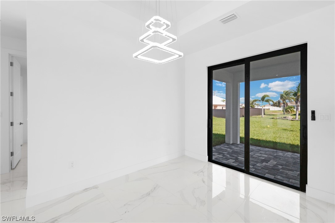 2917 Nelson Road North Cape Coral, FL 33993 - Photo 6 of 25 an empty room with floor to ceiling window and an entryway