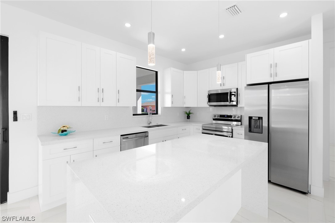 2917 Nelson Road North Cape Coral, FL 33993 - Photo 8 of 25 a kitchen with stainless steel appliances a refrigerator sink microwave and cabinets