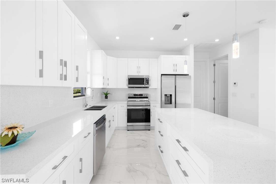 2917 Nelson Road North Cape Coral, FL 33993 - Photo 9 of 25 a kitchen with a sink stainless steel appliances and cabinets