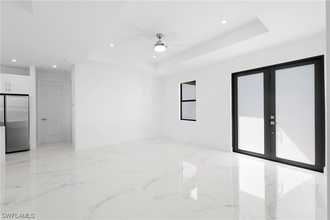 2917 Nelson Road North Cape Coral, FL 33993 - Photo 10 of 25 an empty room with windows and refrigerator