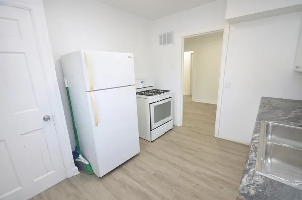 a kitchen with a refrigerator sink and wooden floor