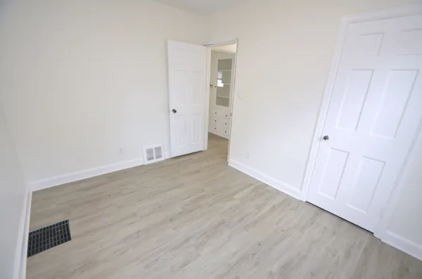 a view of an empty room with wooden floor