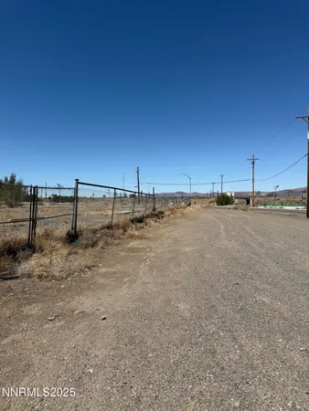 a view of a yard with wooden fence