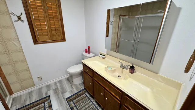 a bathroom with a sink a toilet and shower