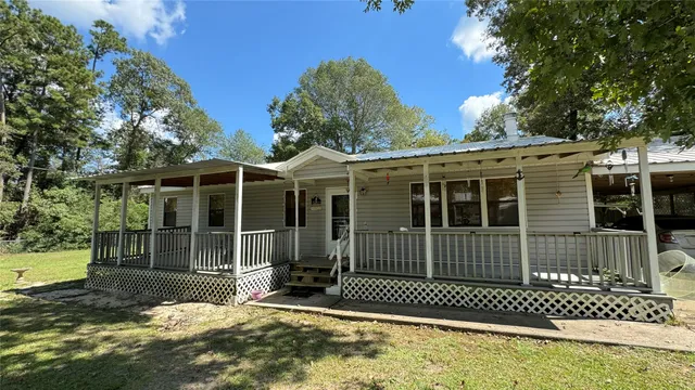 a view of a house with a floor to ceiling window and wooden fence