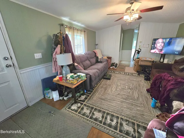 a living room with furniture a chandelier and a flat screen tv