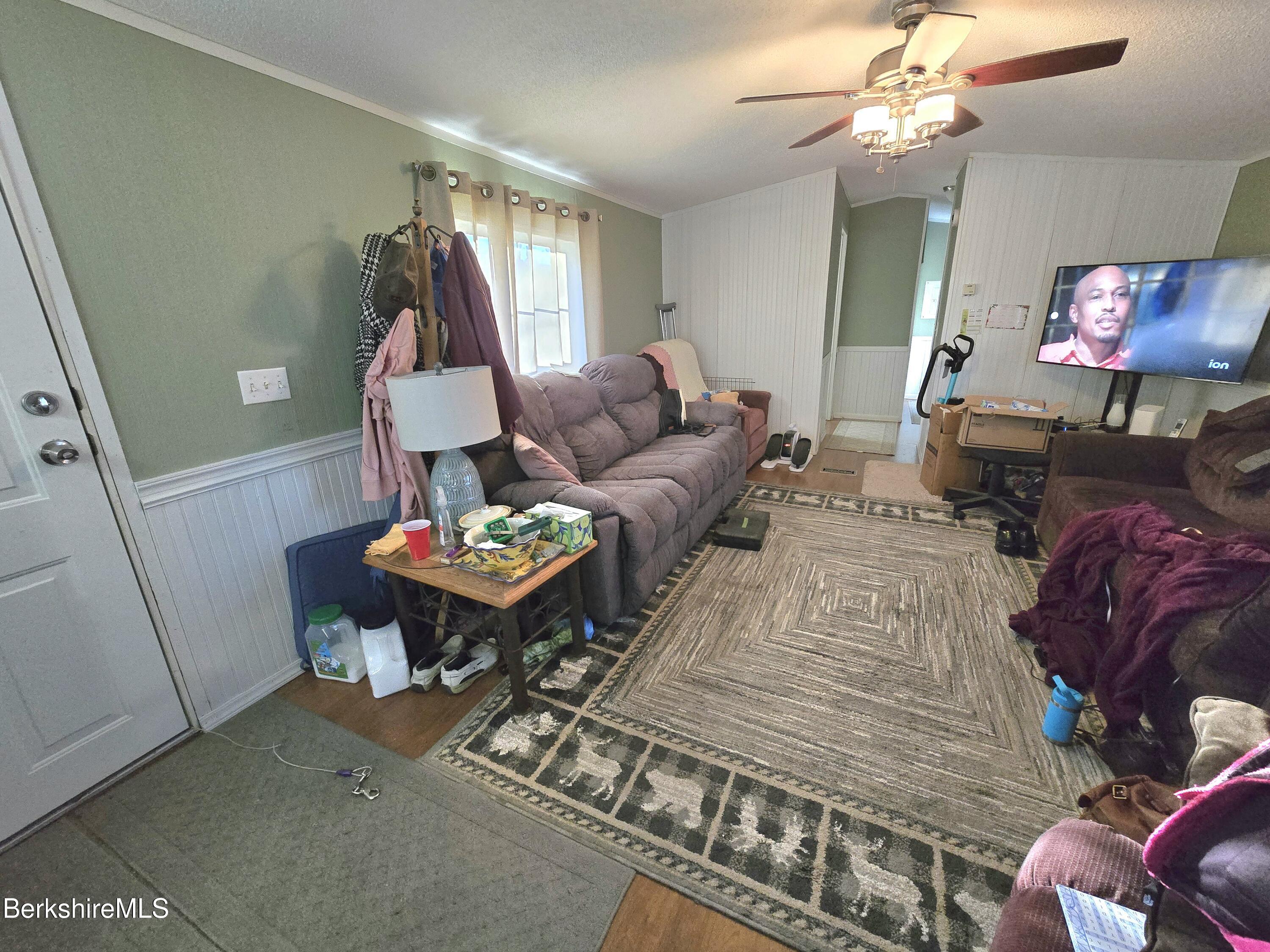 108 Baker Drive Bennington, VT 05201 - Photo 11 of 17 a living room with furniture a chandelier and a flat screen tv