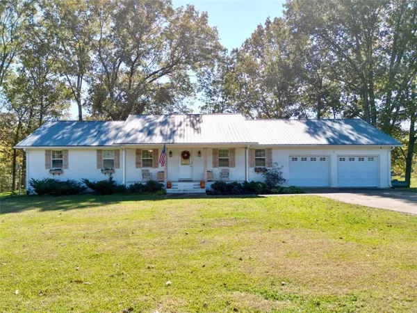 a front view of a house with swimming pool having outdoor seating