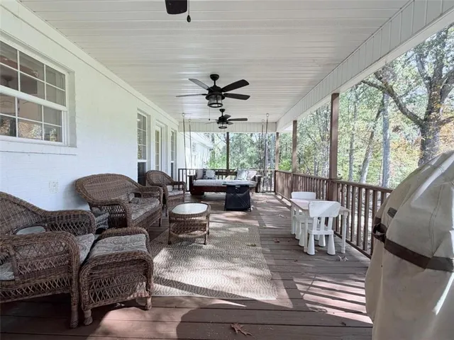 a living room with furniture ceiling fan and a large window