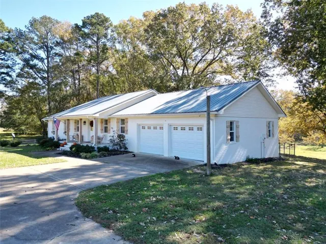 a view of house with yard and trees in front of it