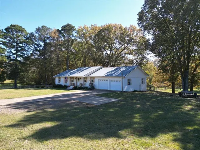 a view of an house with a yard and large tree
