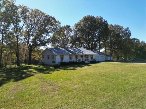 a view of a house with a yard tree and wooden fence