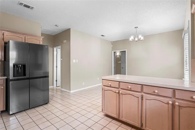 a kitchen with white cabinets and refrigerator
