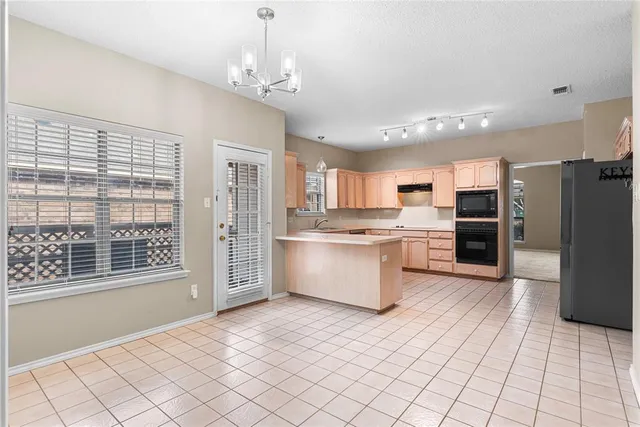a large kitchen with a large window and stainless steel appliances