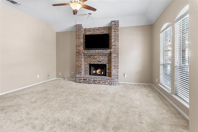 a view of empty room with fireplace and fan