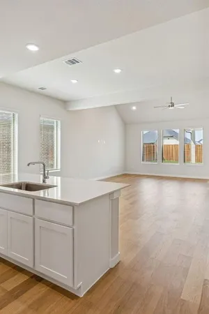 a view of a kitchen with center island and wooden floor