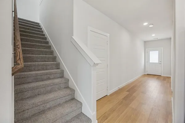 a view of entryway and hall with wooden floor