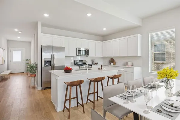 a kitchen with white cabinets and stainless steel appliances