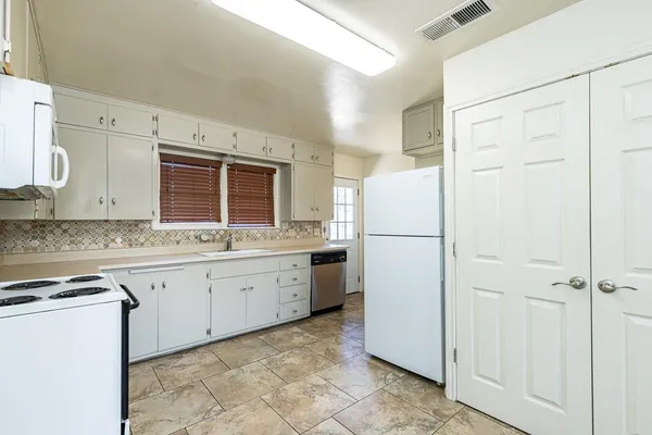 a kitchen with granite countertop cabinets appliances and a sink