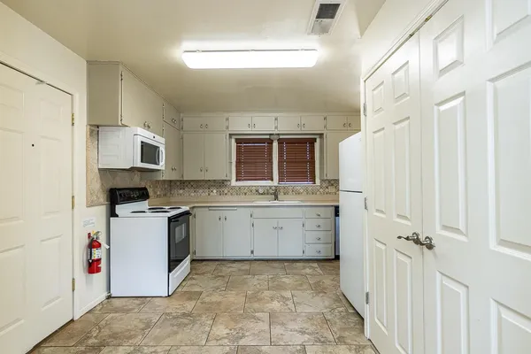 a kitchen with a stove a sink and a refrigerator